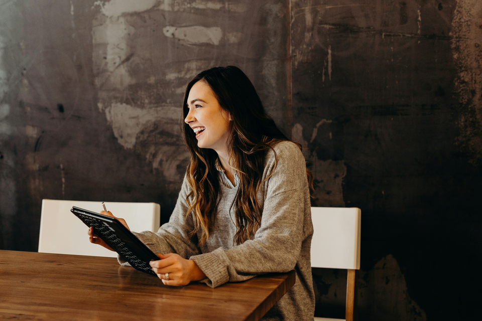 a smiling woman with a tablet