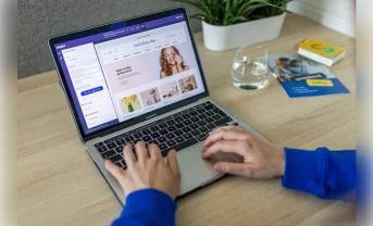 A laptop standing on the table. A person is browsing an ecommerce store related to beauty services and cosmetics.